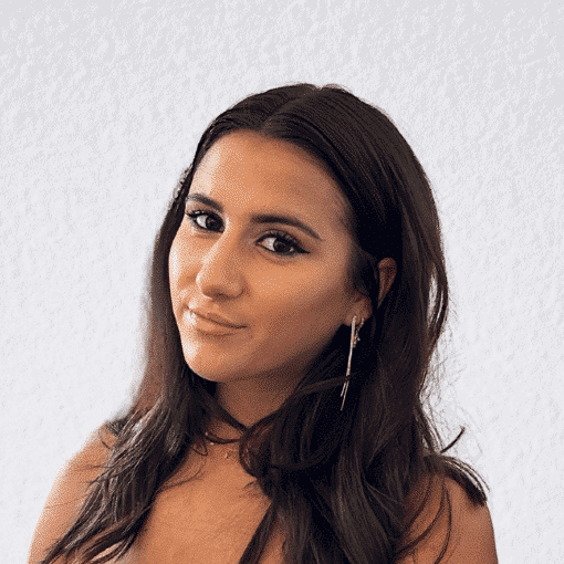 Portrait of a woman with dark hair and earrings, looking confidently at the camera.