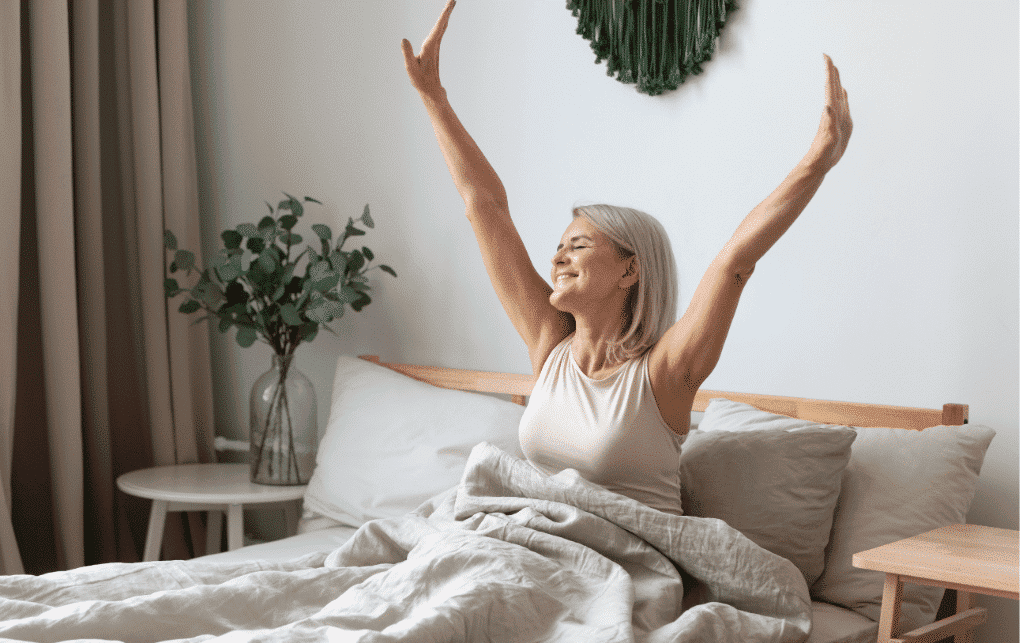 Senior woman stretching in bed for wellness and relaxation.