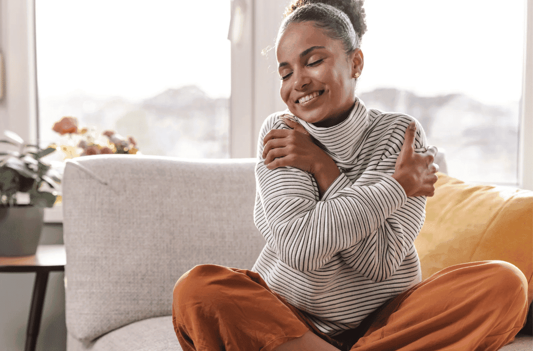 Woman hugging herself as a form of self-care to support her wellness